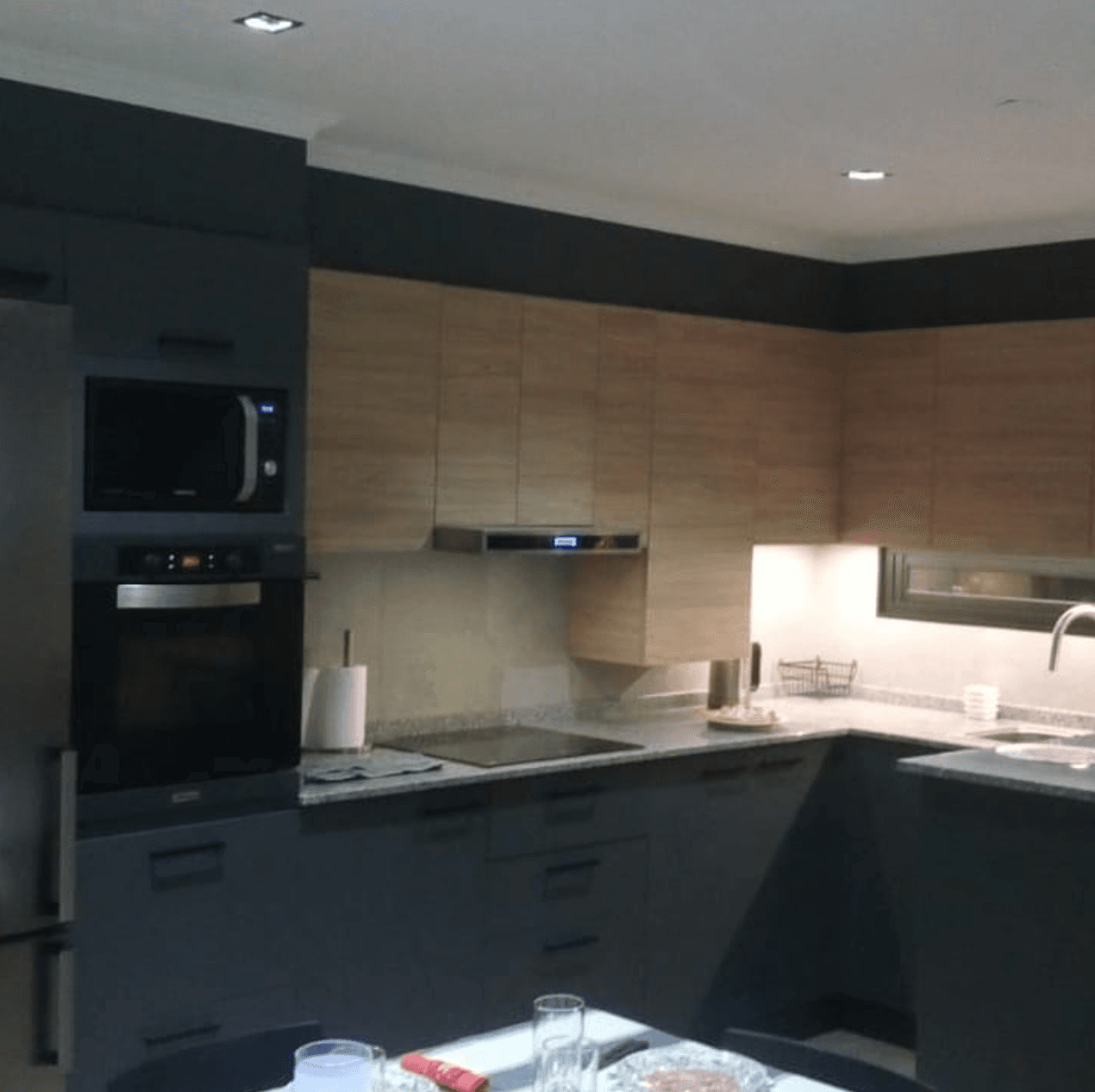 Cocina moderna oscura con electrodomésticos integrados